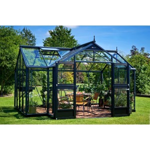 Serra Juliana Orangerie 15, nero-antracite, con piante e area salotto in giardino.