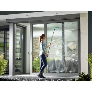 Donna pulisce finestre con tergivetro Leifheit Window Slider M. Attrezzo per pulizia con manico.