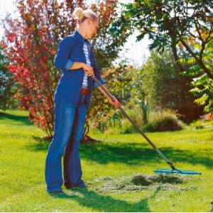 Femme ratissant la pelouse avec le râteau à gazon Gardena combisystem 60 cm dans le jardin.