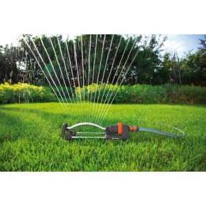 Irrigatore oscillante Gardena Aqua S che irriga il prato. Getti d'acqua visibili.