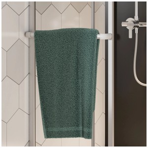 Cabine de douche d'angle Breuer Fara-Kretana avec serviette et cadre argenté. Cabine de douche en verre clair.