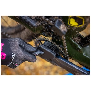 Muc-Off Reinigungsbürste Detailing Brush im Einsatz zur Reinigung eines Fahrrad-Kettenblatts.