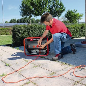 Groupe électrogène Einhell TC-PG 25/1 E5 en utilisation : Générateur avec cadre rouge et câble branché.