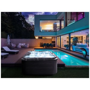 Spa extérieur Beliani Arcelia gris avec eau illuminée et éclairage LED sur terrasse en bois.