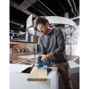 Uomo che sega legno con seghetto alternativo a batteria Bosch Professional GST 18 V-125 B.
