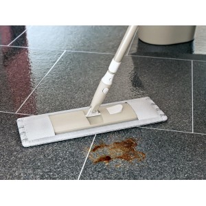 Housse de balai OBI en microfibre sur carrelage foncé enlève une tache de saleté. Idéale pour nettoyage humide.