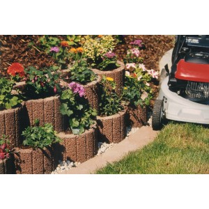 Grand anneau de plantation marron (env. 48x25cm) en béton pour stabilisation de pente au jardin.