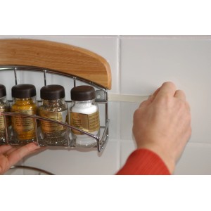 Utilisation des Tesa Powerstrips Large pour fixer une étagère à épices sur un mur carrelé.