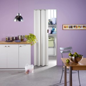 Weiße Falttür Una, 84x205 cm, im modernen Wohnraum. Platzsparende Tür für Standardrahmen.