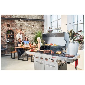 Barbecue a gas Char-Broil Professional PRO S 4 in acciaio inox con ospiti che grigliano.