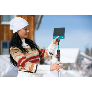Femme fixant un outil Gardena combisystem sur un manche en bois (130 cm).