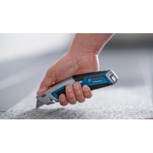 Couteau à tapis universel Bosch Professional en utilisation, coupe de la moquette.