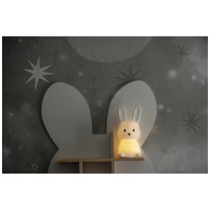 Veilleuse LED Functional Bunny : Lapin blanc avec lumière chaude sur une étagère devant un fond étoilé.