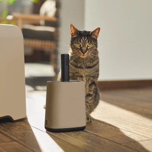 Pelle Rotho Biala avec support cappuccino pour litières, avec un chat en arrière-plan.