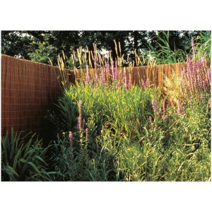 Natte d'osier Provence comme brise-vue de balcon dans un jardin avec des plantes fleuries.