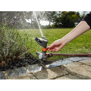 Arroseur Gardena Comfort arrosant la pelouse. Arroseur à impulsion, circulaire et sectoriel en utilisation.