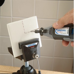 Fresa a spirale Dremel 562 che fresa una piastrella di ceramica, bloccata in una morsa.