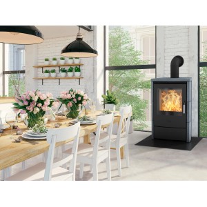Cuisinière Fireplace Meltemi en stéatite noire 8 kW dans salon avec table à manger et chaises.