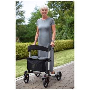 Rollator Ridder Ivo noir avec panier et siège. Femme utilisant le rollator dans le jardin.