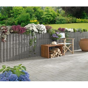Muro da giardino realizzato con blocchi per piante Kann Gala Flair grigi, piantati con fiori.