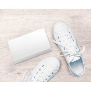 Confezione da 6 gomme magiche accanto a sneakers bianche su legno chiaro.