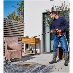 Einhell Idropulitrice a batteria Hypresso 18/24 in uso: uomo pulisce mobili da giardino con l'idropulitrice.