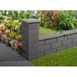 Mur de jardin anthracite en demi-pierres (25x20x25 cm) servant de limite de propriété.