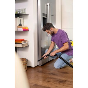 Homme utilisant une buse flexible Kärcher pour aspirer un joint. Accessoire flexible pour aspirateurs eau et poussière.
