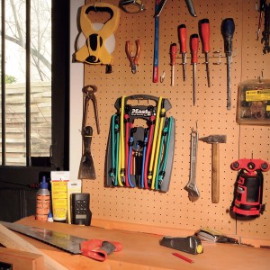 Jeu de sandows Master Lock, 10 tendeurs colorés dans un support sur un mur d'outils.