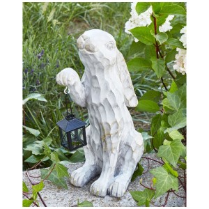 Cremeweisse Gartenfigur Kaninchen aus Magnesiumoxid mit Laterne, detailreich, stehend im Grünen. Rustikale Dekoration.