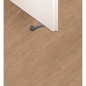 Cale-porte lilas Dooneo en PVC, placée sous une porte blanche sur un plancher en bois.