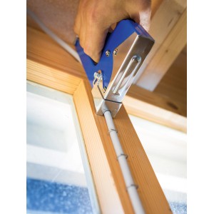 LUX Hand Tacker Classic che fissa un cavo a una cornice di legno.