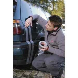 Un homme applique du ruban adhésif universel Tesa Extra Power argenté sur une voiture. Ruban polyvalent.