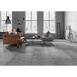 Grès cérame Pietra Gris 30x60 cm posé dans un salon avec des meubles.