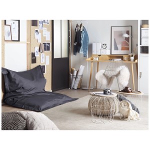 Pouf Beliani Fuzzy nero in soggiorno moderno. Grande e comodo pouf in nylon su tappeto chiaro.