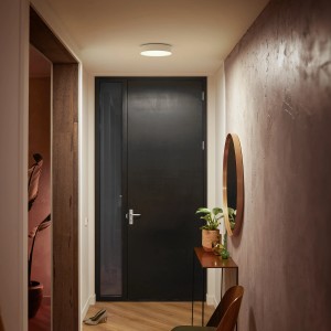 Plafoniera Philips Hue Enrave bianca e rotonda con dimmer nel corridoio.