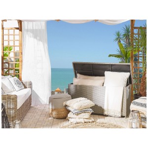 Coffre de rangement pour coussins Beliani Modena en rotin gris ouvert avec coussins et couvertures sur une terrasse.