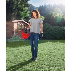 Frau nutzt Einhell Power X-Change GE-US 18 Li Universalstreuer im Garten.