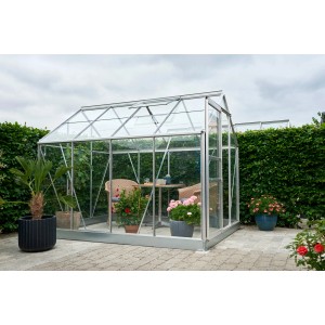 Serre Halls Popular 86 Alu 5 m² lumineuse avec plantes et coin salon dans le jardin.