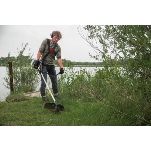 Homme utilisant une débroussailleuse à essence Al-Ko BC 500 B dans le jardin. Coupe-bordure à essence pour l'entretien de la pelouse.
