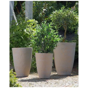 Trois pots de fleurs Beliani Camia beige sable de différentes tailles dans le jardin.