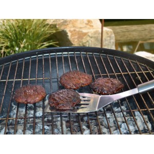 Barbecue avec steaks hachés et spatule du set de 3 ustensiles pour barbecue.