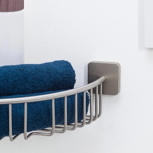 Étagère d'angle de douche Onu de Tiger en acier inoxydable brossé avec serviette bleue.