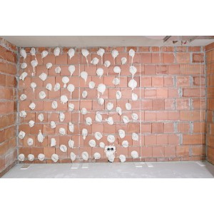Gesso adesivo Knauf Perlfix applicato su una parete di mattoni all'interno.