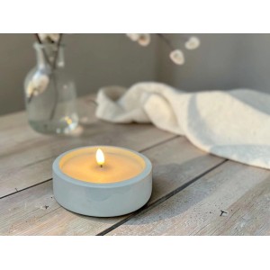 Blaue LED-Kerze im runden Zement-Topf mit Timer, warmweißem Flackerlicht auf Holztisch. Gemütliche Dekoration.