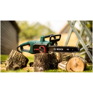 Tronçonneuse électrique Bosch UniversalChain 35 coupant des bûches dans le jardin.