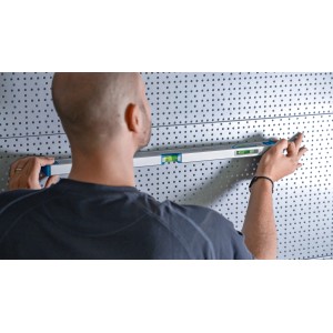 Un homme utilisant un niveau à bulle Bosch Professional (60 cm) sur un mur.