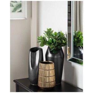 Vaso decorativo Qanawat in gres dorato, con due vasi scuri e piante verdi su un tavolo.