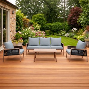 Greemotion Monaco Sitzgruppe, 4-teilig, mit beigen Kissen auf Holzterrasse vor Garten.