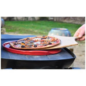 Roter Emile Henry Pizzastein gerillt mit Pizza auf Grill mit Pizzaschieber.